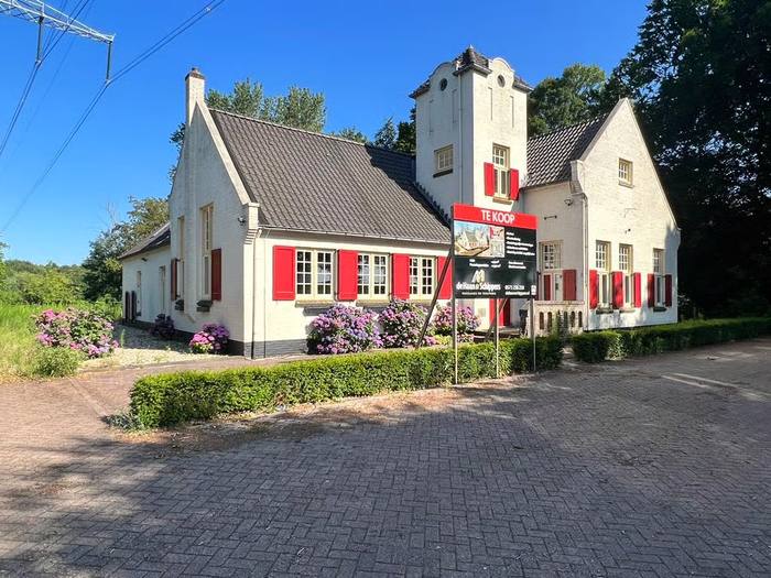 Exterieur zomer · witte gevel met rode luiken, torentje · hoogspanningsmast zichtbaar